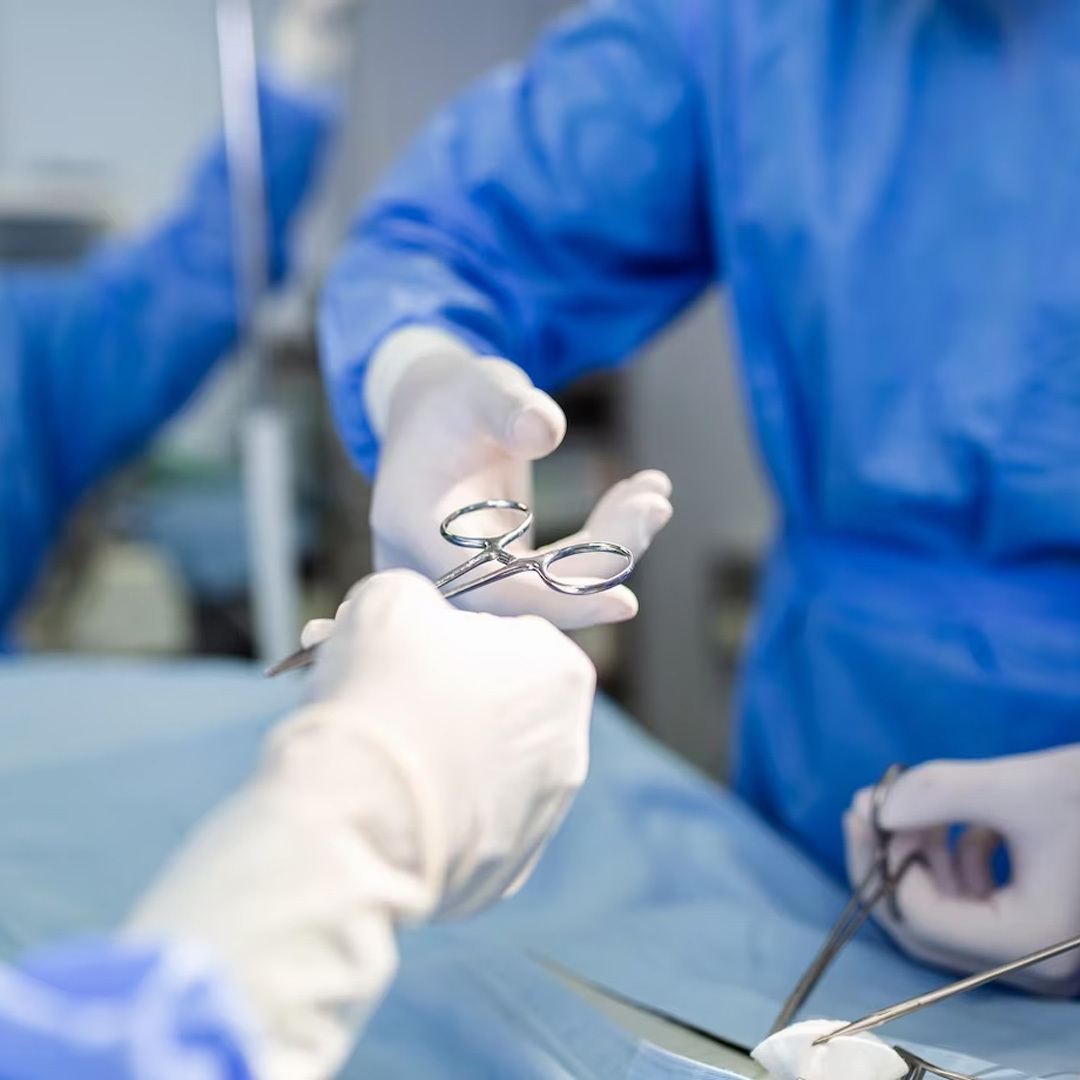 a Gynae surgeon holding scissor in his hand while performing surgeries